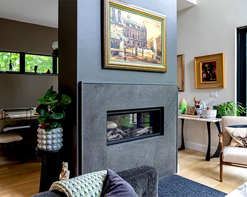 Modern fireplace featuring a custom-crafted dark stone surround and hearth installed in Peabody, MA.